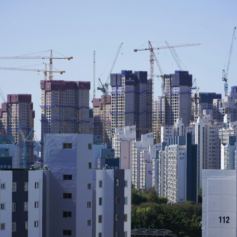 Numbered apartment blocks and construction cranes in a Korean city