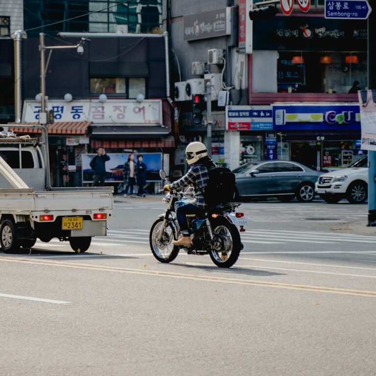 A motorcycle and a small truck on a Korean neighbourhood street